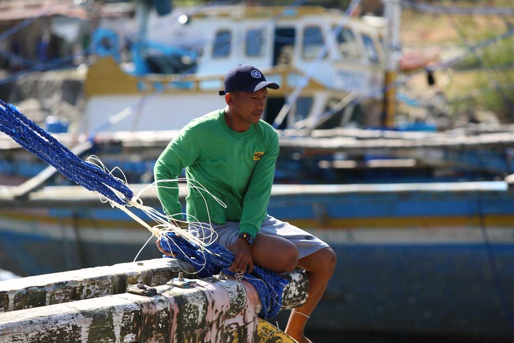 Perched on a giant wooden spar in the heat of the midday, servicing the ship that will be his home for months at a time. Photo: RFA