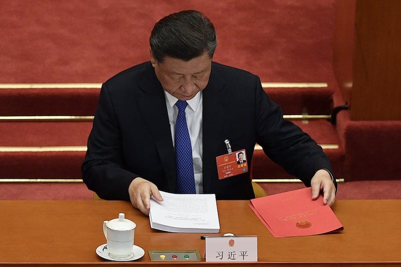 图为,2020年5月28日,习近平在北京人民大会堂举行的全国人民代表大会闭幕会议时准备文件。(法新社)