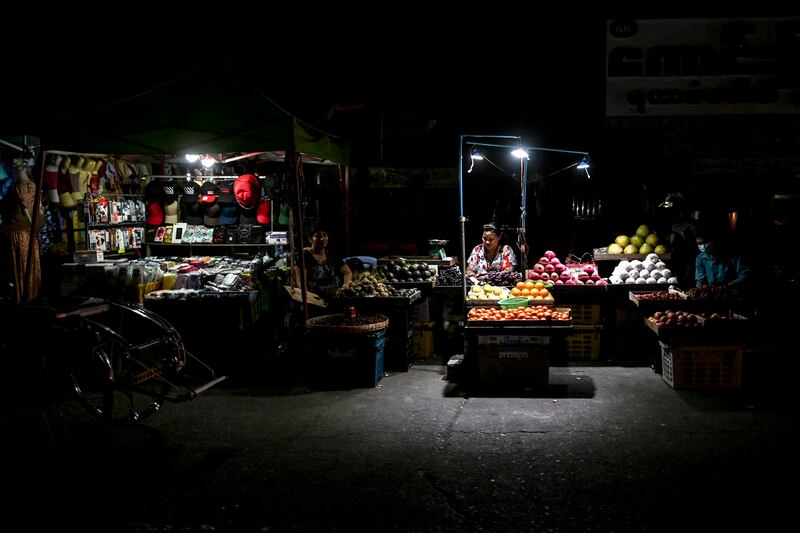 Street vendors wait for customers March 3, 2022, during one of the frequent power outages in Yangon, Myanmar. Economic mismanagement has hamstrung the military's budget. Credit: AFP