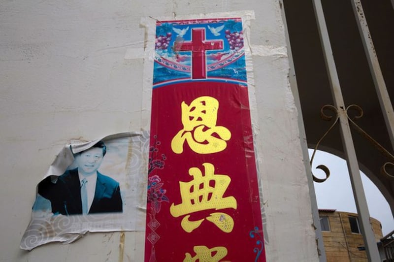 中国一家庭教会外面的基督教十字架标志以及褪色的习近平画像(美联社资料图)
