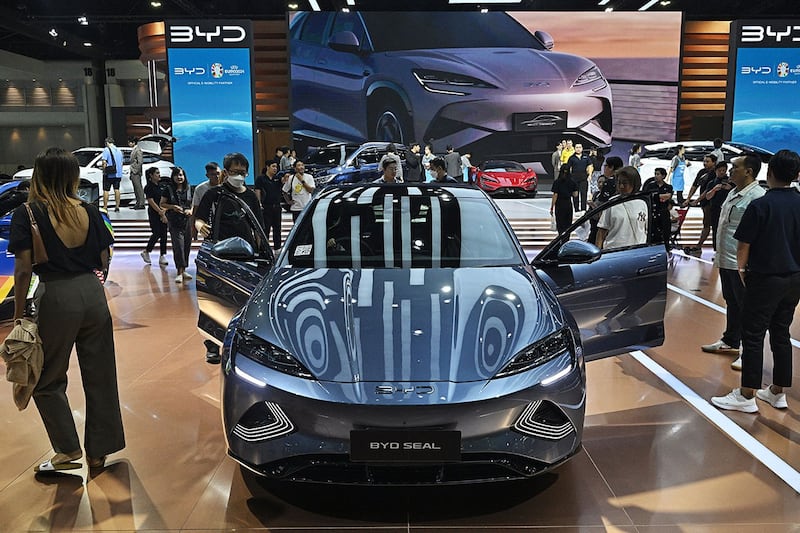 2024年3月27日,人们在曼谷国际车展上观看中国电动汽车比亚迪的海豹车型。(法新社)