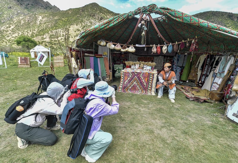 Tourists take photos at the Nomadic Culture Tourism Festival on June 15, 2024 in Urumqi, Xinjiang Uyghur Autonomous Region of China.