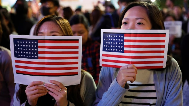 2019年11月28日,两名香港抗议者举着美国国旗在街头抗议。(美联社)
