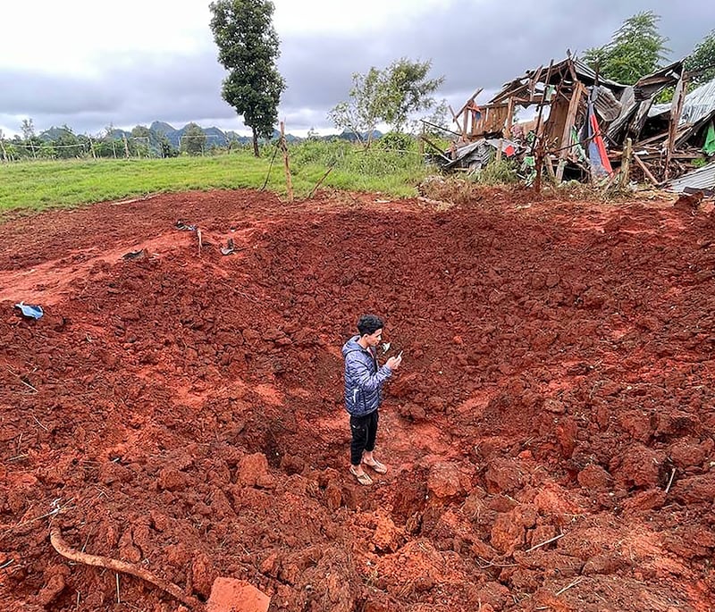 A man stands in a bomb crater at a camp for internally displaced people after junta airstrikes near Pekon township in Myanmar's south Shan state on Sept. 6, 2024.