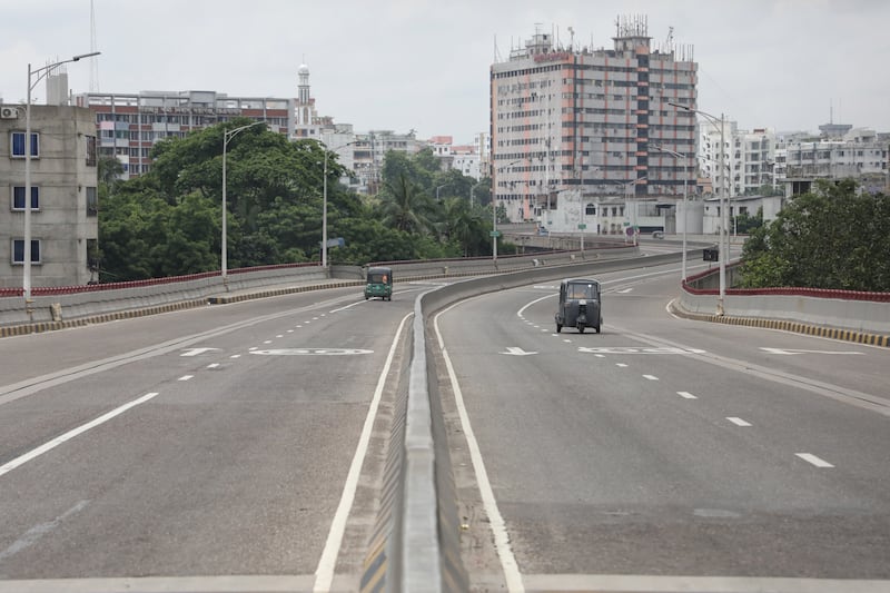 Two auto rickshaws are seen on an otherwise empty road during a nationwide curfew in the Jatrabari area in Bangladesh's capital, Dhaka, July 22, 2024. [Jibon Ahmed/BenarNews]