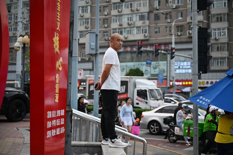 2024年7月9日,一名男子站在北京一个繁忙的路口。(法新社)