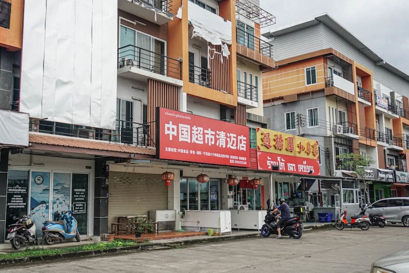 2024年11月10日,一名摩托车手在泰国清迈杭东区中文广告前停车。